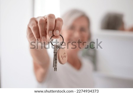 Blurred smiling woman holding home keys. House of dream. Female happy winner buyer renter tenant of new home apartment, proud homeowner looking at camera showing keys of modern flat Royalty-Free Stock Photo #2274934373