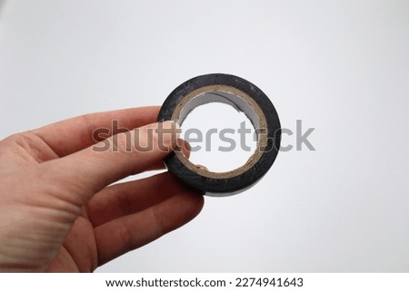 Black electric wire insulation tape used for insulate fasten seal up and suspend cables and wires on white background