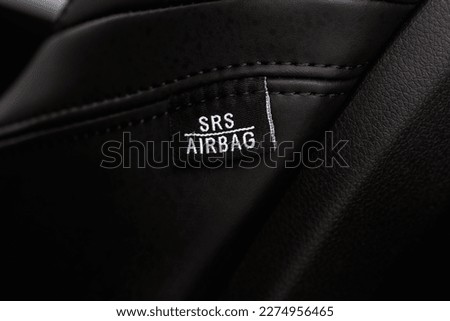 Close up view of airbag label on the side of a car seat. Airbag safety system symbol on the car seat. Modern car interior details.