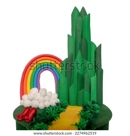 Many character in wizard of OZ. Magical fantasy team on cake made of craft paper. Emerald city gate and rainbow. Design cake of the theme is inspired by the movie wizard of OZ
