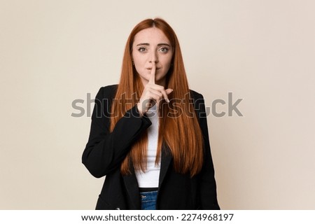 Young business caucasian redhair woman keeping a secret or asking for silence.
