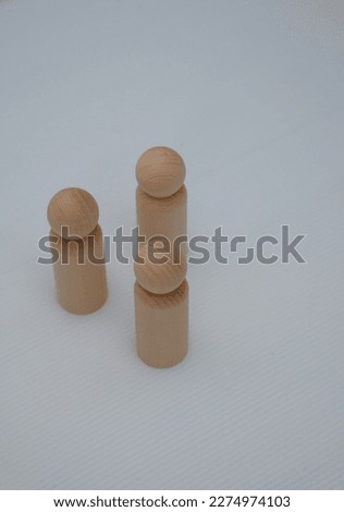 knobbed wooden cylinders place in group isolated on white background. Hierarchy, ranking, teamwork concept. Selective focus