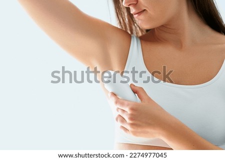 Woman using deodorant stick for sweating protection Royalty-Free Stock Photo #2274977045