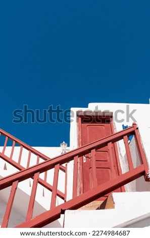 Vertical shot of the colorful outdoor stairs in the village on the island of Mykonos in Greece against the blue sky