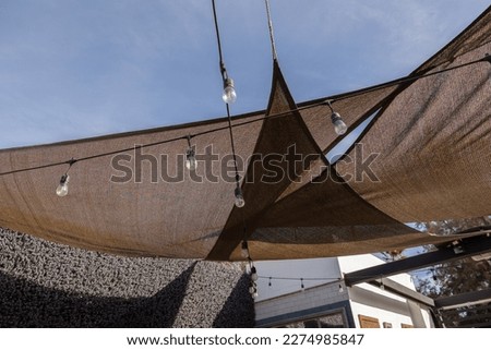 Ensenada, Baja California, Mexico - Brown awning with string lights covering an outdoor patio on a sunny day