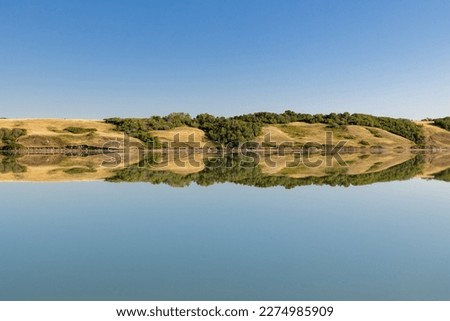 Reflection in Little Manitou Lake, Saskatchewan, Canada across from Manitou Beach and hot springs Royalty-Free Stock Photo #2274985909