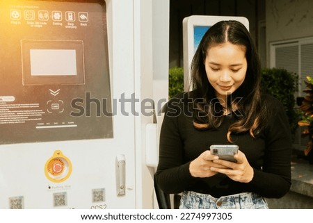 Young asian woman driving an EV electric vehicle using app to find convenient gas station charging an electric car and using scanned barcode to connect to the car to charge DC power to the battery
 Royalty-Free Stock Photo #2274997305