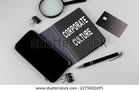 CORPORATE CULTURE text written on a black notebook with smartphone, magnifier and credit card