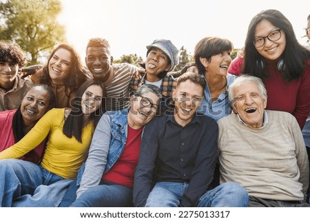 Group of multigenerational people smiling in front of camera - Multiracial friends of different ages having fun together - Main focus on caucasian senior faces Royalty-Free Stock Photo #2275013317