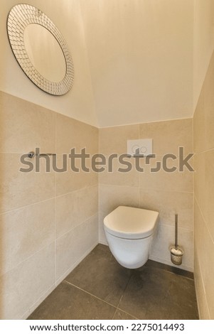 a toilet in the corner of a bathroom with a round mirror on the wall above it and an open door