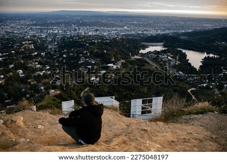 A man in the Hollywood hills overlooking the city of Los Angeles.