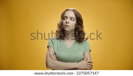 Closeup photo of amazing brunette lady looking up empty space, her hands crossed, deep thinking creative person wear casual green t shirt isolated yellow color background