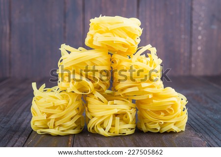 Raw pasta on wooden background - process old dark style picture