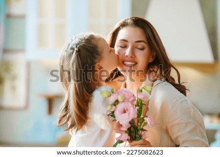 Happy mother's day. Child daughter congratulating her mother and giving her bouquet of flowers.