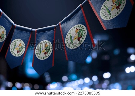 A garland of Belize national flags on an abstract blurred background.
