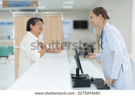 Doctor talking and asking about the health of an elderly patient with a friendly smiling face.