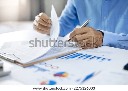 Asian businessman read business contract and checking investment chart before sign to start new business and start new investment project in the future