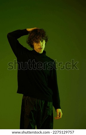 Man smile fashion and style accessories model with curly hair, stylish hairstyle, hipster dance teen lifestyle, portrait green background mixed neon light, copy space