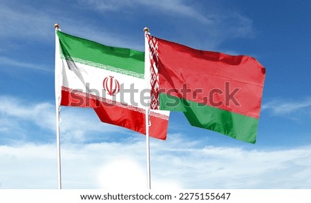 Iran flag and Belarus flag on cloudy sky. waving in the sky Royalty-Free Stock Photo #2275155647