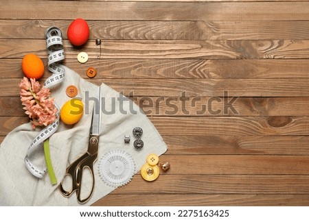Sewing supplies with Easter eggs and hyacinth flower on wooden background