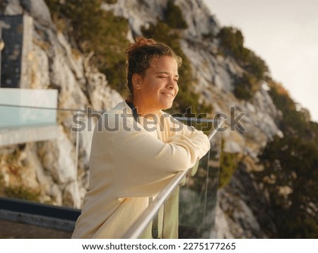 woman enjoys the view from the viewpont over Oludeniz, Turkey. Sunset, clouds, paragliders. Mount Babadag