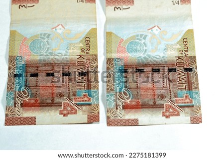 The reverse side of Kuwaiti quarter dinar brown paper banknote cash money bill currency features A traditional wooden Kuwaiti door and the first Kuwaiti coin issue 2014 isolated on white background