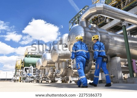 workers in an industrial plant for the production and processing of crude oil  Royalty-Free Stock Photo #2275186373