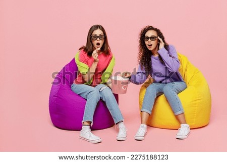 Full size young two friends shocked surprised amazed astonished women in 3d glasses watching movie film in cinema sit in bag chair isolated on pastel plain light pink color background studio portrait Royalty-Free Stock Photo #2275188123