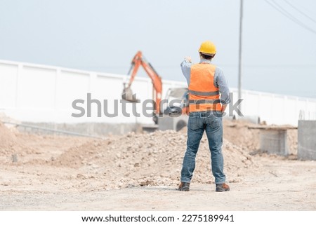 Portrait  Professional American Heavy Industry Engineer Wearing Safety Uniform, Glasses and Hard Hat, Looking into the Camera. Confident American Industrial Specialist Standing in a Factory Facility.