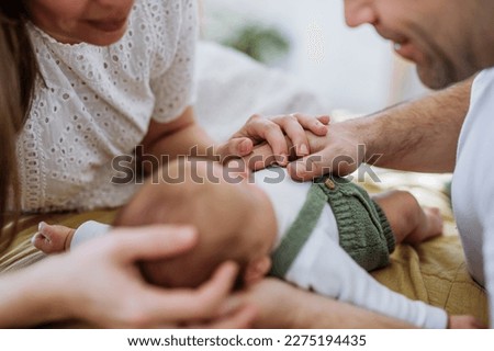 Happy parents cuddling with their newborn baby. Royalty-Free Stock Photo #2275194435