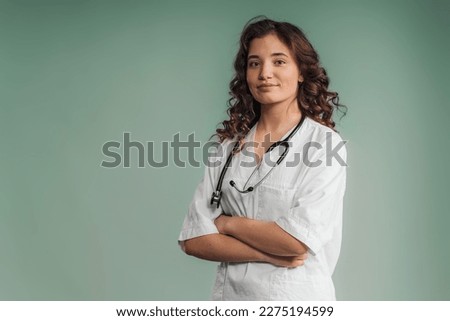 Portrait of young curly nurse, studio shoot. Royalty-Free Stock Photo #2275194599