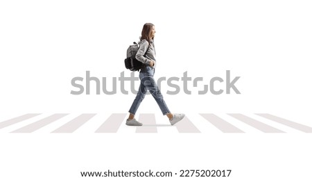 Female student with a backpack walking on a pedestrian crossing isolated on white background Royalty-Free Stock Photo #2275202017