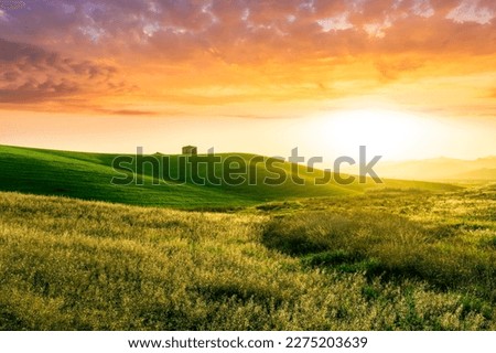 countryside sunset in green hills of spring fields with old castle farm and mountains on background of evening landscape Royalty-Free Stock Photo #2275203639