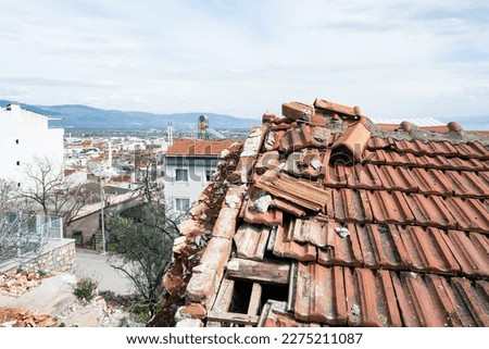 Hole in tiled roof of abandoned house Royalty-Free Stock Photo #2275211087