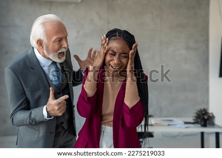 Burnout young businesswoman manager crying suffering from mental health breakdown, overwhelmed with stress at work because of furious senior businessman boss who is yelling at her. Royalty-Free Stock Photo #2275219033