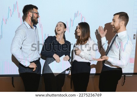 Group of business people working. Technical price graph and indicator, red and blue candlestick chart and stock trading computer screen background. Traders analyzing data.