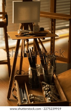 Painting supplies in artist studio. Table with palette, oil color and tool in an art workshop. Selective focus and soft background with copy space.
