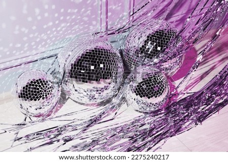 Shiny disco balls and foil fringe curtain indoors, color toned Royalty-Free Stock Photo #2275240217