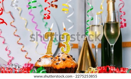 Solemn cake for an anniversary with a number  73. Happy birthday background with champagne bottle and champagne glasses. Beautiful holiday decorations copy space.
