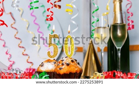 Solemn cake for an anniversary with a number 50. Happy birthday background with champagne bottle and champagne glasses. Beautiful holiday decorations copy space.