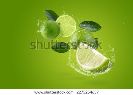 Water splashing on Fresh green lime isolated on green background