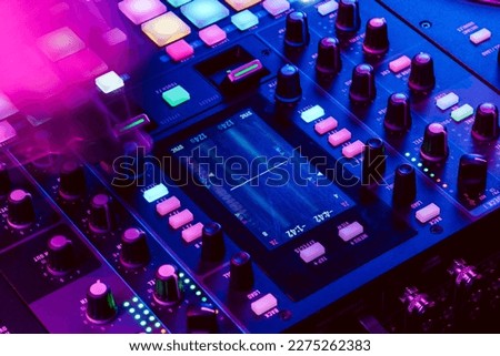 Close up of DJ mixing console in party light Royalty-Free Stock Photo #2275262383