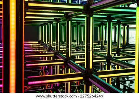 Futuristic neon red yellow green light cube art installation. Technology cyber cube, Sci fi shape. Abstract conceptual background with colorful neon cubes.
