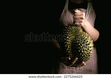 Farmer hand holding Ripe durian the king of tropical fruits. Royalty-Free Stock Photo #2275266623