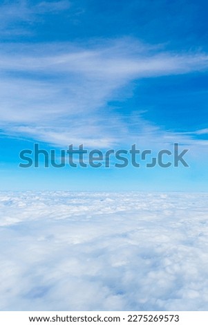 A view of the blue sky and fluffy clouds, a picture taken from the window of an airplane.