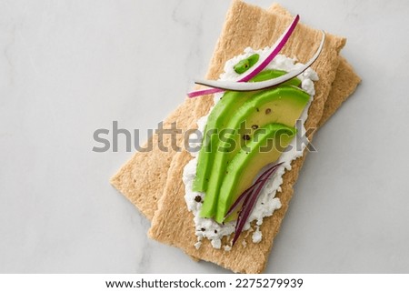 Crispbread with avocado and cream cheese. Top view. Royalty-Free Stock Photo #2275279939