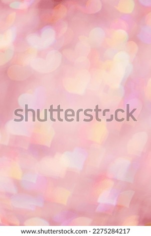 Abstract bokeh background pink color, natural flare from lights as hearts, pink monochrome vertical photo, optical effect, blurred bokeh texture as romance holiday backdrop, celebration screensaver