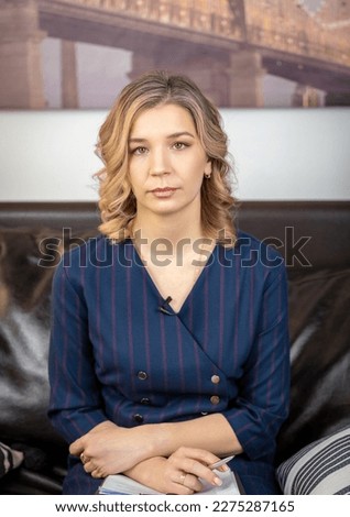 Portrait of a successful female psychologist in her office, notebook in hand, on the couch