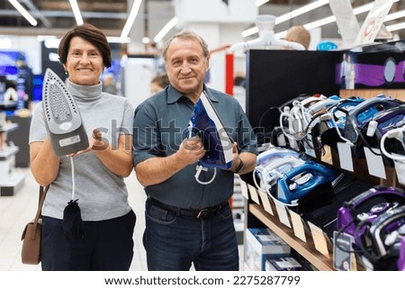 Elderly man and elderly woman choose iron Royalty-Free Stock Photo #2275287799