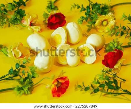 Happy Easter. Easter picture with handmade eggs on a yellow background with flowers. A holiday card. Baking in the form of Easter eggs is an interesting alternative to Easter cakes. New trends